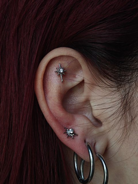 Ear with a star-shaped helix stud, a star lobe stud and stacked lobe hoops