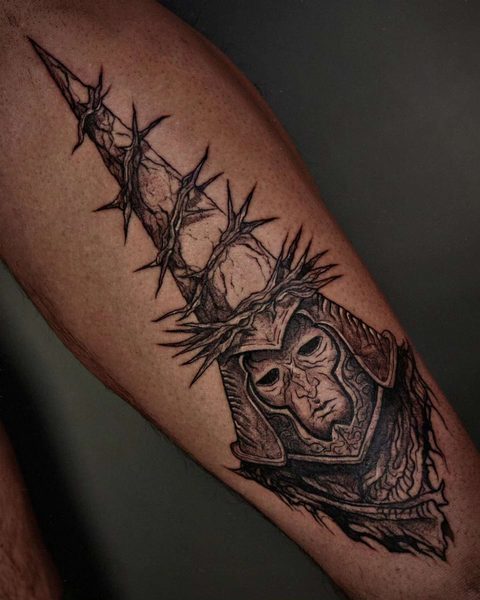 Forearm tattoo of a masked warrior in a tall spiked helmet wrapped in thorns